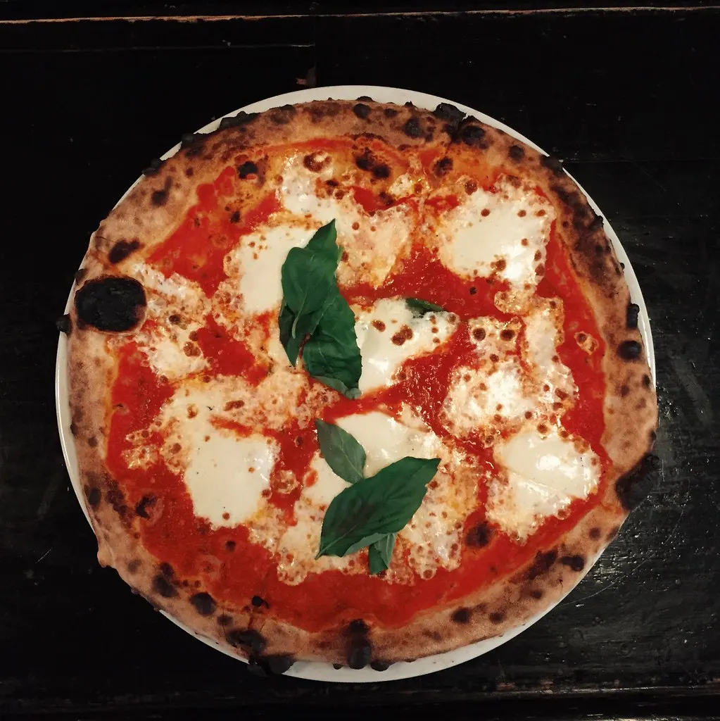 A margherita pizza with tomato, mozzarella and basil