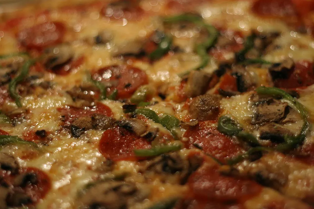 A loaded meat pizza with salami and peppers